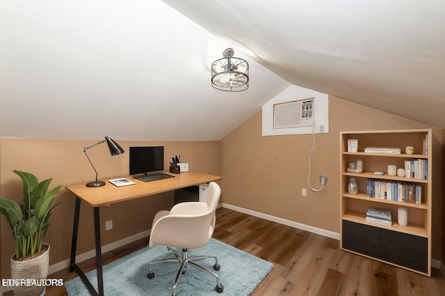 home office featuring hardwood / wood-style floors, lofted ceiling, and a wall mounted air conditioner