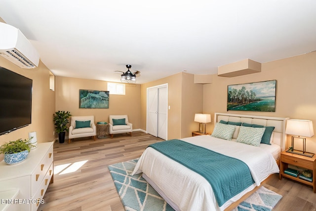 bedroom featuring light hardwood / wood-style flooring, a closet, and a wall unit AC