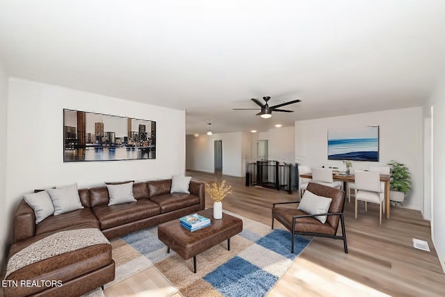 living room with light hardwood / wood-style floors and ceiling fan