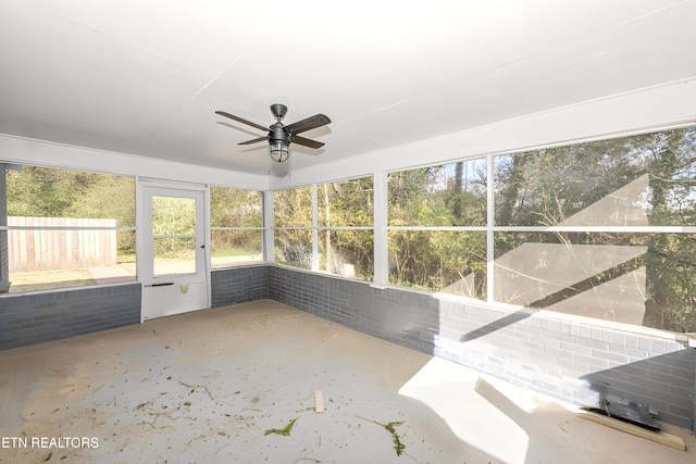 unfurnished sunroom featuring ceiling fan