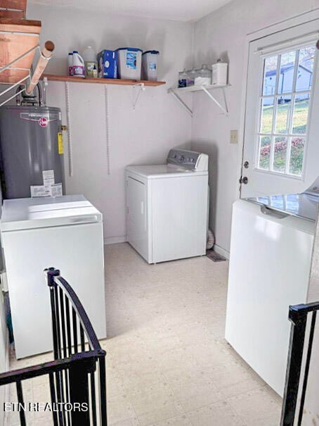 washroom with water heater and washing machine and clothes dryer