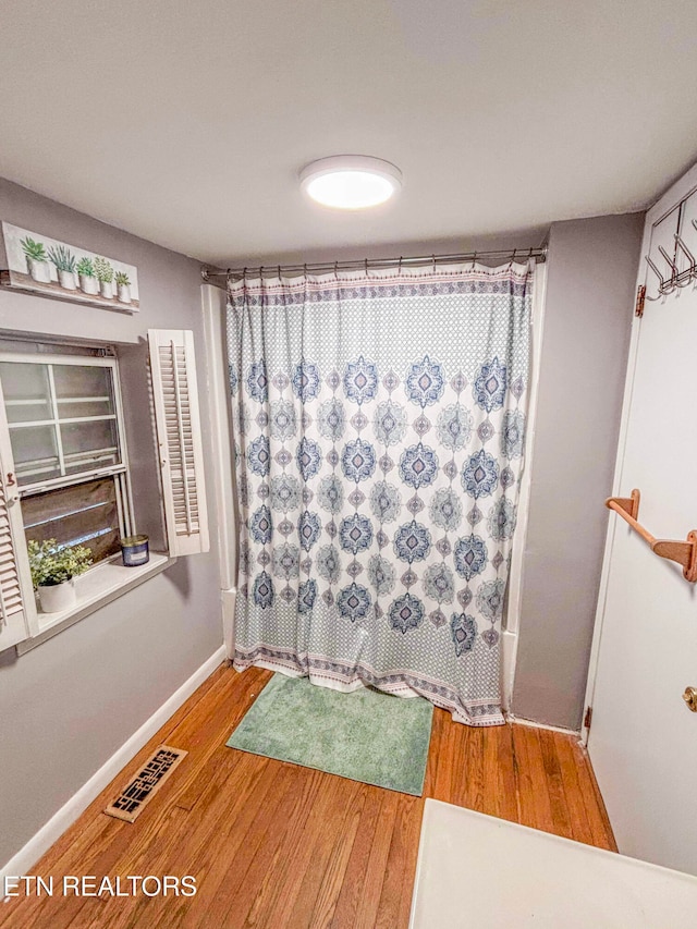 bathroom featuring hardwood / wood-style flooring and shower / tub combo