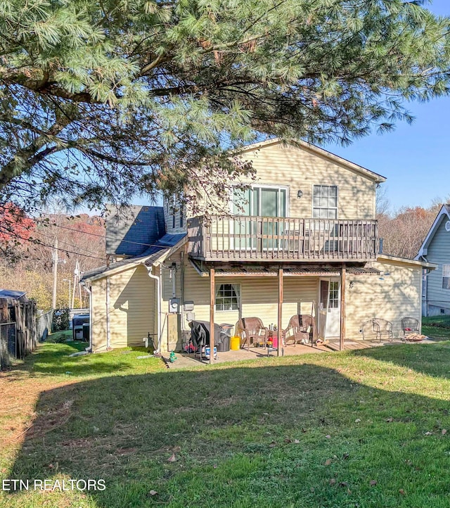 rear view of house with a lawn, a patio area, and a wooden deck