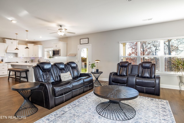 living room featuring ceiling fan and dark wood-type flooring