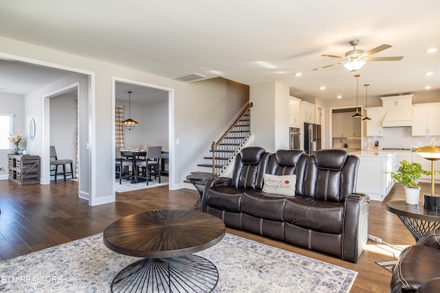 living room featuring ceiling fan and dark wood-type flooring