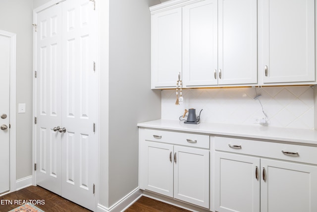 interior space featuring tasteful backsplash, white cabinetry, and dark hardwood / wood-style flooring