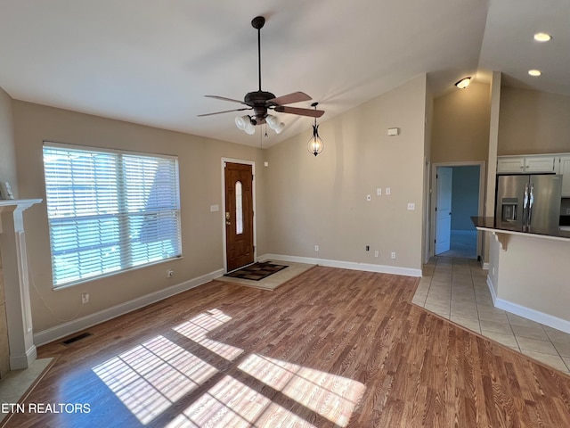 interior space with light wood-type flooring, ceiling fan, and lofted ceiling