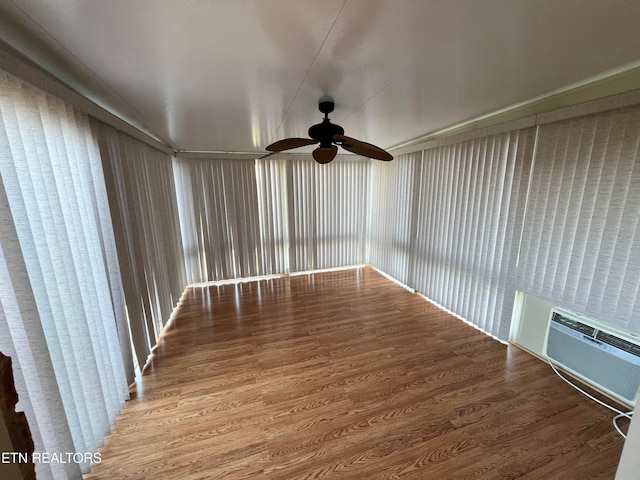 unfurnished sunroom featuring a wall mounted AC and ceiling fan