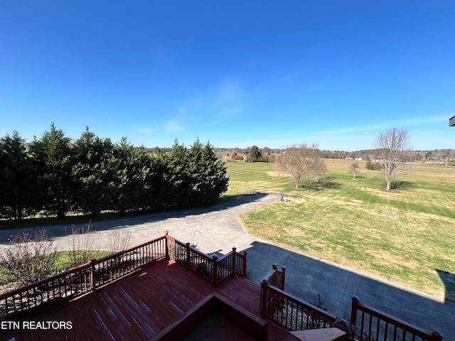 dock area with a rural view, a yard, and a wooden deck