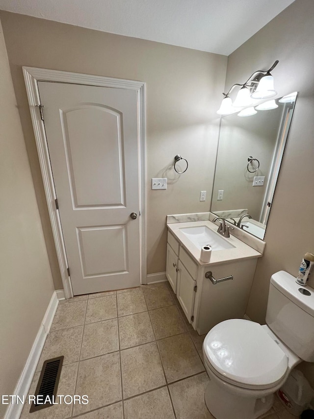 bathroom featuring toilet, vanity, and tile patterned floors