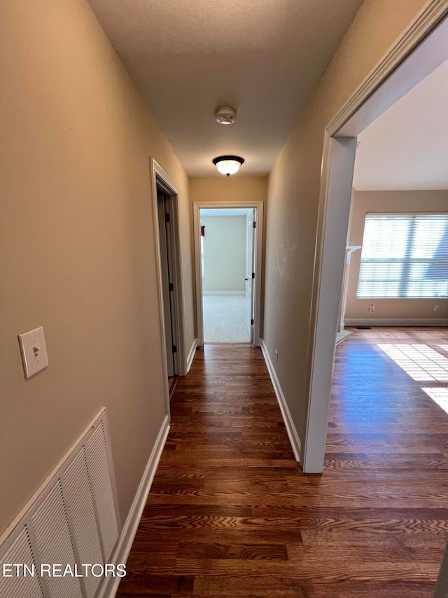 corridor with dark hardwood / wood-style flooring