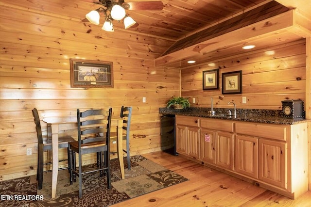 dining area with wooden walls, sink, wooden ceiling, and light hardwood / wood-style floors