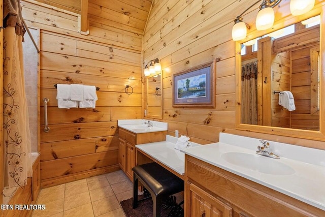 bathroom with tile patterned floors, wood walls, curtained shower, and vanity