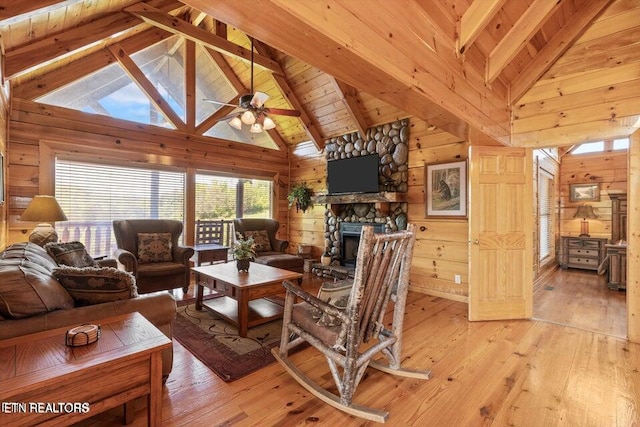 living room featuring wood walls, light hardwood / wood-style flooring, and beamed ceiling