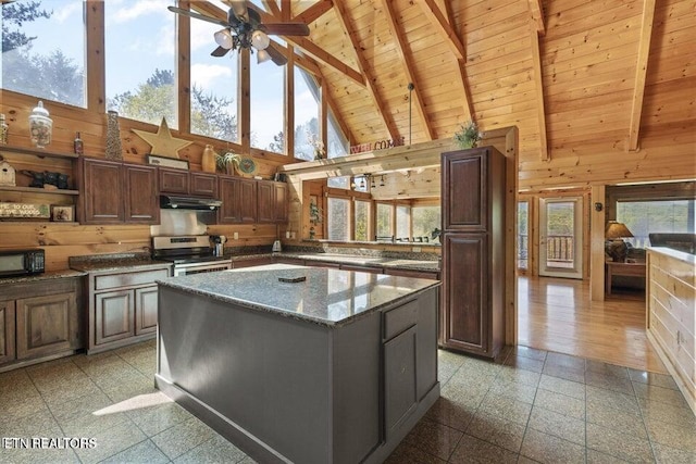 kitchen with beamed ceiling, high vaulted ceiling, a center island, and stainless steel range