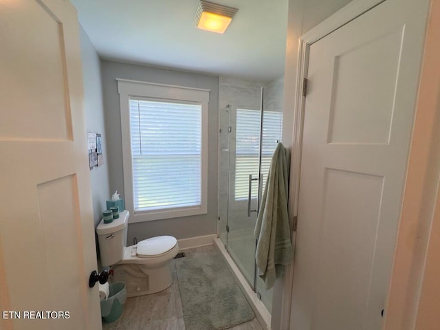 bathroom featuring walk in shower and toilet