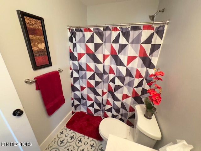 bathroom featuring tile patterned floors, a shower with curtain, and toilet