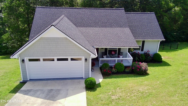 view of front of house featuring a porch, a garage, and a front yard