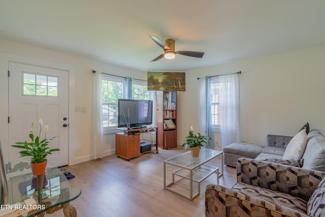 living room with light hardwood / wood-style flooring and ceiling fan