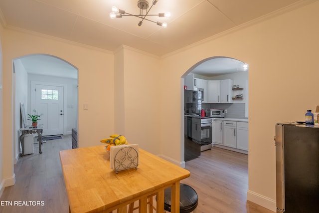 dining space with an inviting chandelier, light hardwood / wood-style flooring, and crown molding