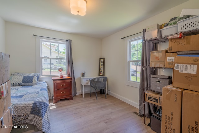 bedroom featuring light hardwood / wood-style flooring and multiple windows