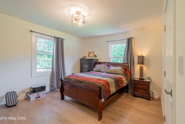 bedroom with light wood-type flooring and multiple windows