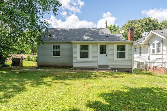 rear view of property featuring a yard