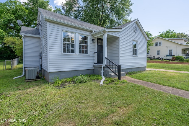 view of front of home with central AC and a front yard