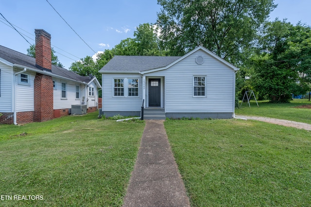 bungalow-style house with central AC unit and a front lawn