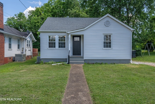 bungalow-style house featuring a front yard and cooling unit