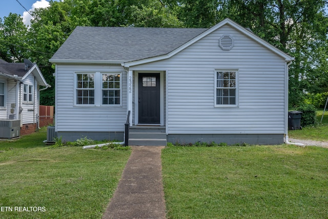 bungalow featuring a front yard and central AC unit