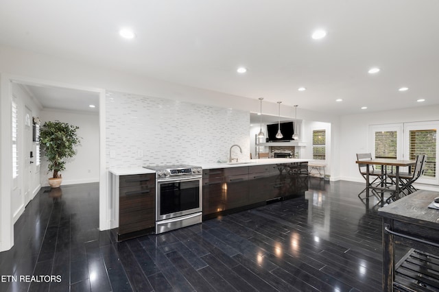 kitchen featuring pendant lighting, sink, stainless steel electric range, dark hardwood / wood-style flooring, and decorative backsplash