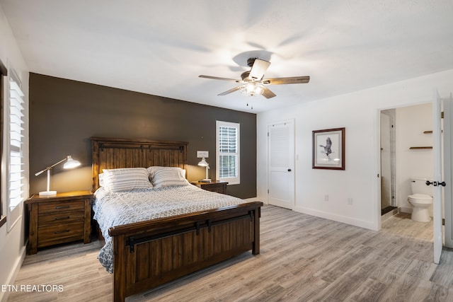 bedroom featuring ceiling fan, ensuite bath, and light hardwood / wood-style flooring