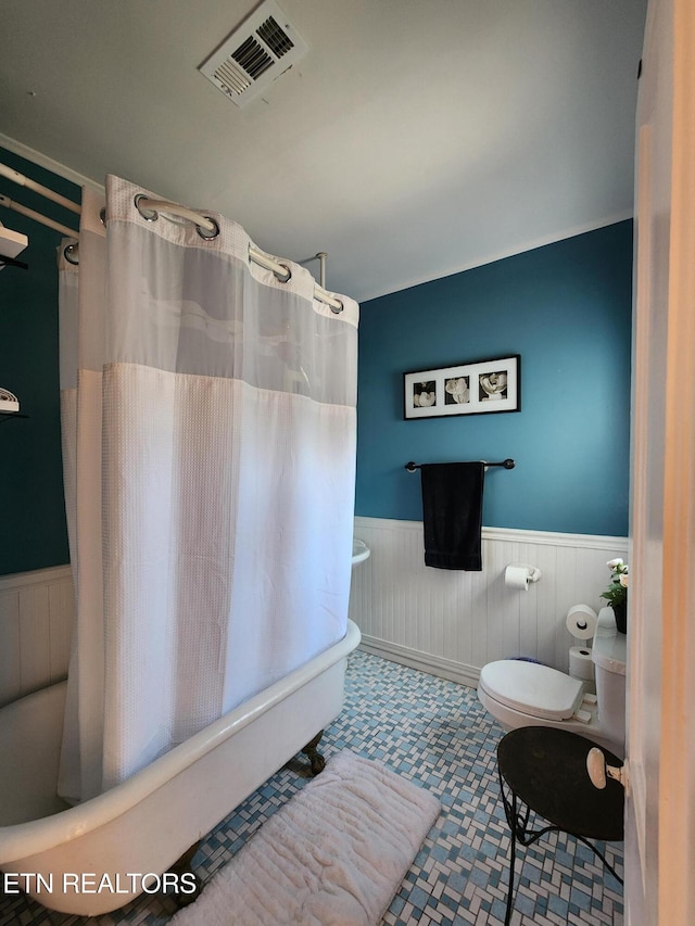 bathroom with shower / bathtub combination with curtain and toilet