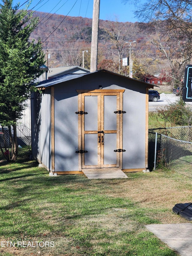 view of outbuilding with a mountain view and a yard