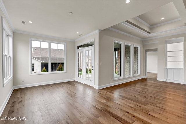 spare room featuring hardwood / wood-style floors, built in features, and ornamental molding