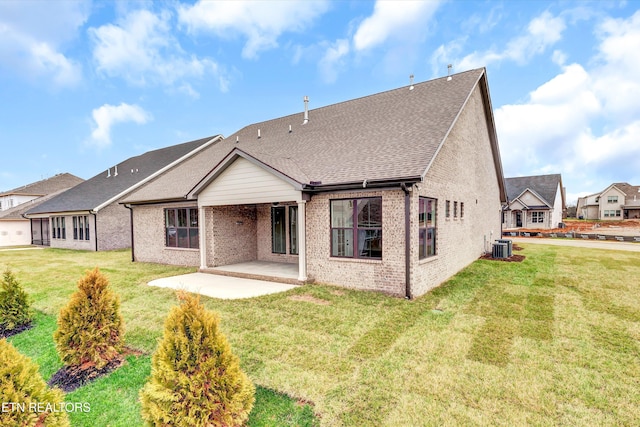 back of property with a yard, a patio, and central AC