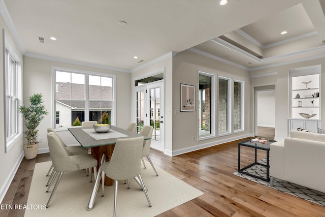 dining space featuring light wood-type flooring and crown molding