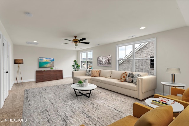 carpeted living room with ceiling fan