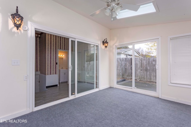 spare room with dark colored carpet, ceiling fan, and vaulted ceiling