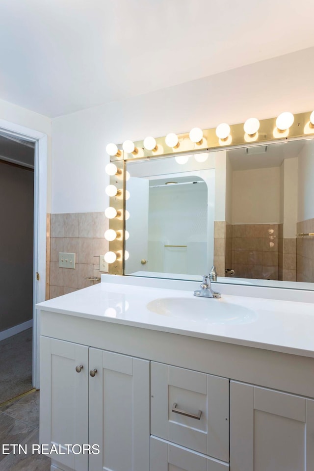 bathroom with vanity and tile walls