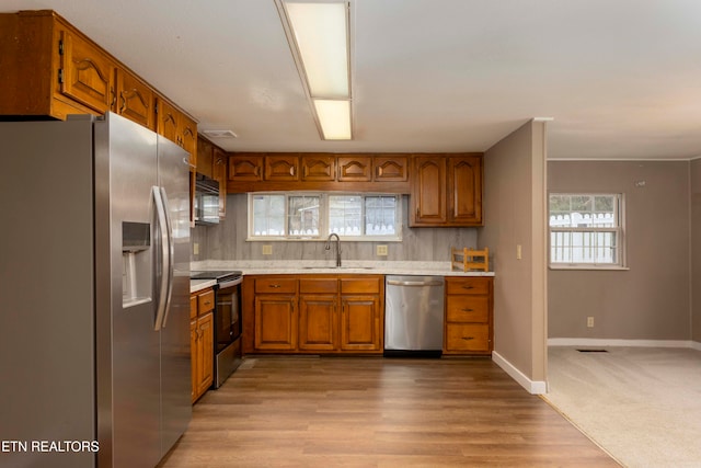 kitchen with light hardwood / wood-style floors, sink, and appliances with stainless steel finishes