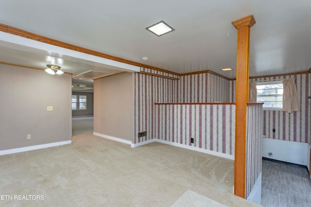 carpeted spare room featuring crown molding