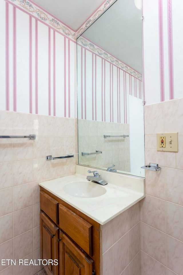 bathroom with vanity and tile walls