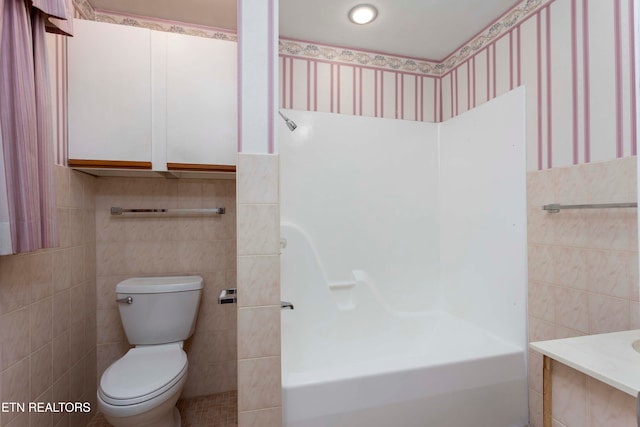 bathroom featuring toilet, tile walls, and a tub