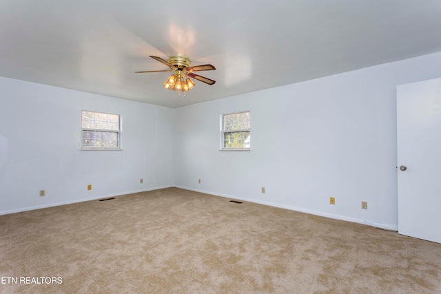 carpeted spare room with ceiling fan