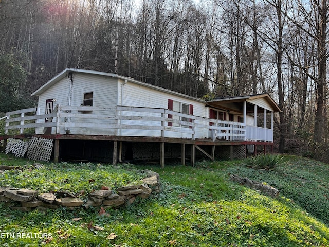 rear view of property featuring a wooden deck