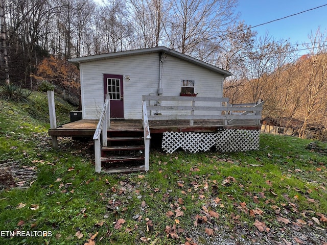 rear view of property with a lawn and a deck