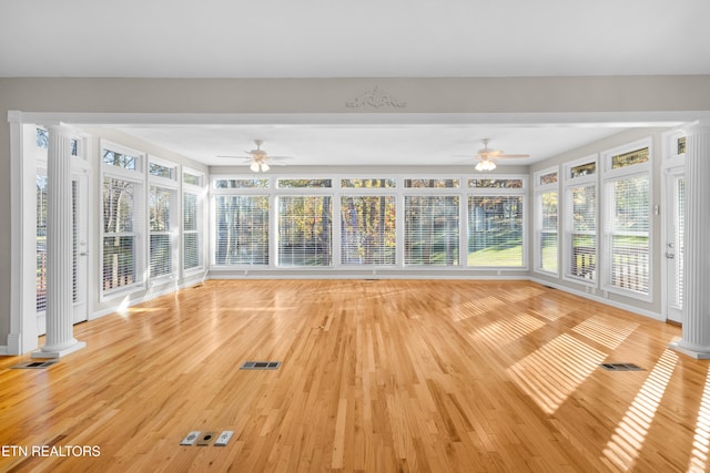 unfurnished sunroom with ceiling fan