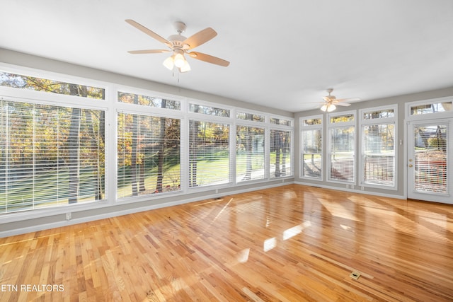 unfurnished sunroom with ceiling fan